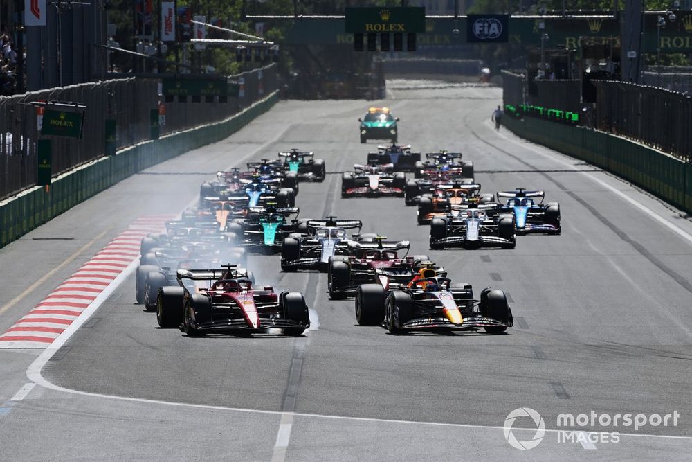 Charles Leclerc, Ferrari F1-75, Sergio Perez, Red Bull Racing RB18, battle for the lead ahead of Max Verstappen, Red Bull Racing RB18, Carlos Sainz, Ferrari F1-75, the rest of the field at the start