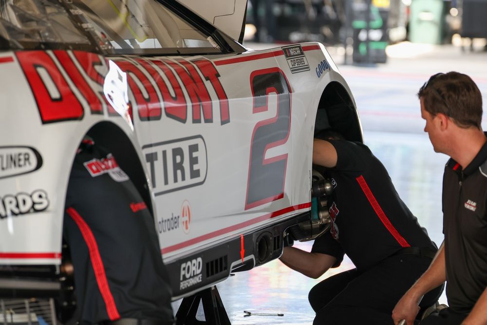 Crew working inside wheel wells of Austin Cindric's Team Penske Ford