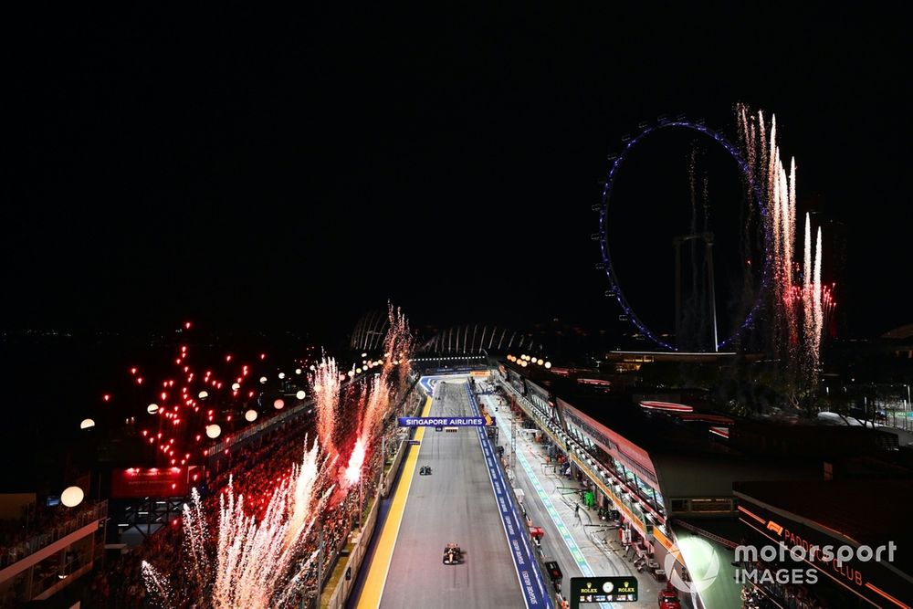 Fireworks light the sky at the end of the race as Oscar Piastri, McLaren MCL38, Fernando Alonso, Aston Martin AMR24, cross the line