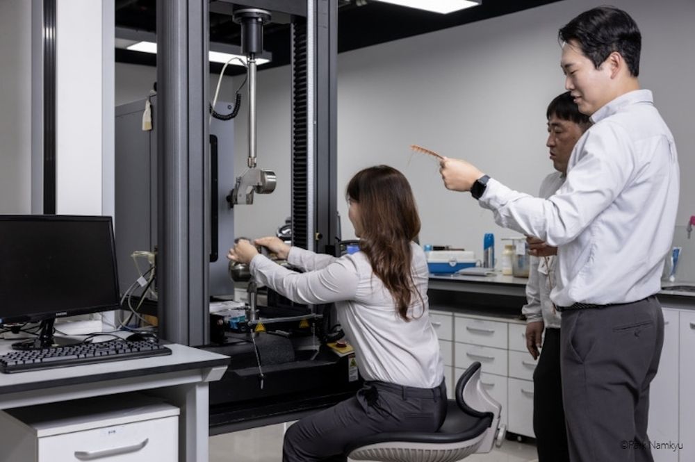 Membri del progetto di sviluppo degli pneumatici di Formula E impegnati nel test della tensione della corda tessile nel laboratorio Code del Technodome Hankook