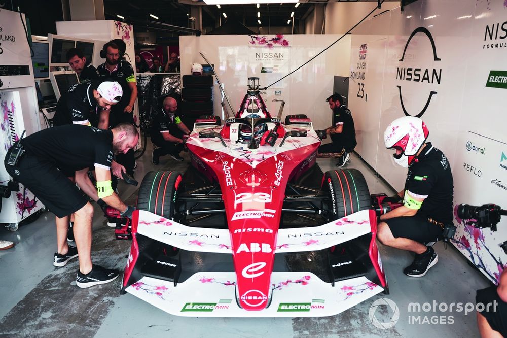 Team members work on the car of Oliver Rowland, Nissan Formula E Team in the garage