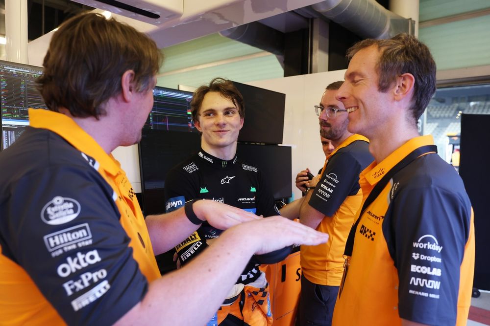 Oscar Piastri avec son équipe dans le garage McLaren.