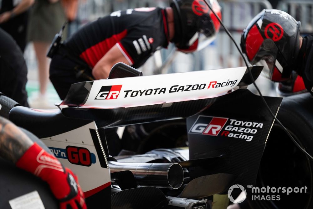 Haas team members practice a pit stop. Toyota branding is visible on the rear wing