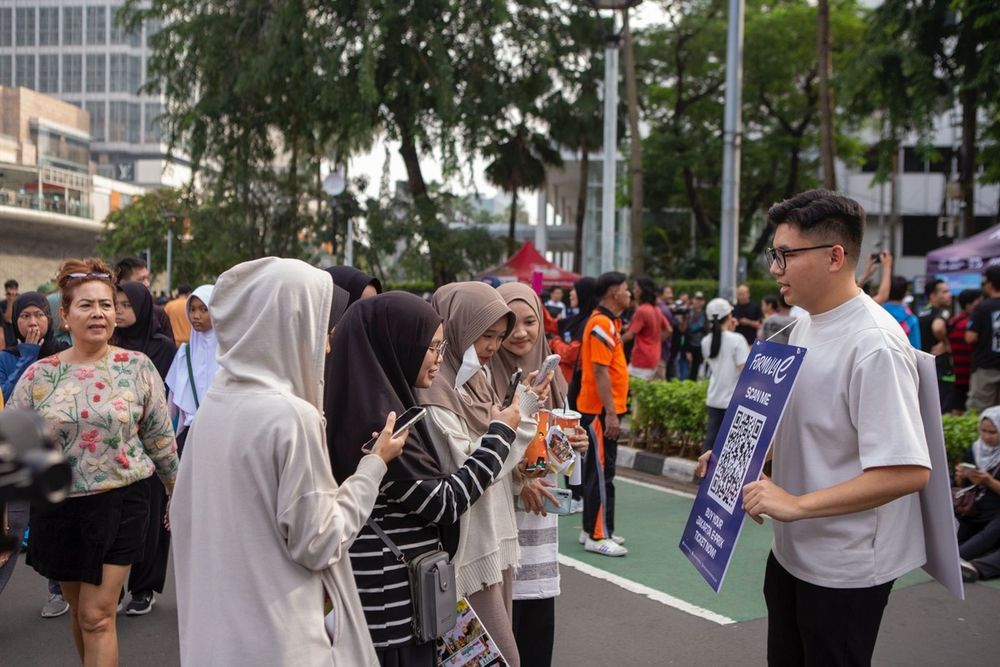 Petugas dari Jakpro membagikan informasi tentang Jakarta E-Prix 2025 kepada pengunjung CFD