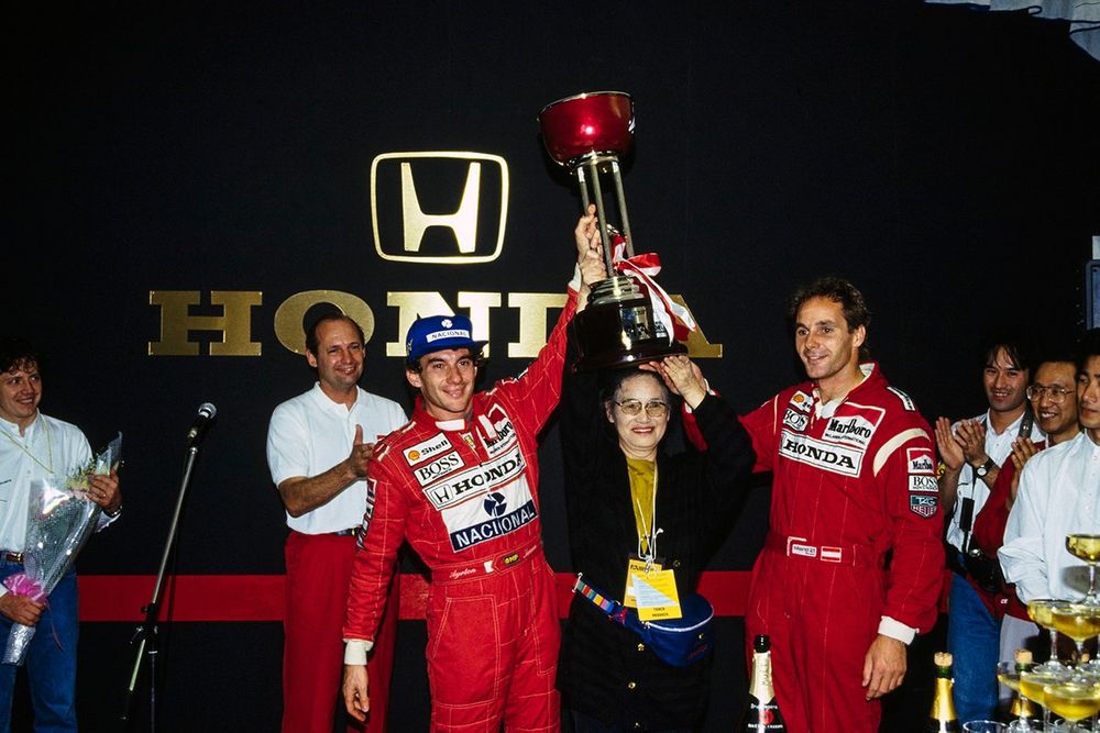 Stefano Modena, Tyrrell 020 Honda y Ron Dennis miran mientras Ayrton Senna, McLaren Honda, y Gerhard Berger, McLaren Honda, sostienen en alto el trofeo y celebran el 1-2 en la carrera