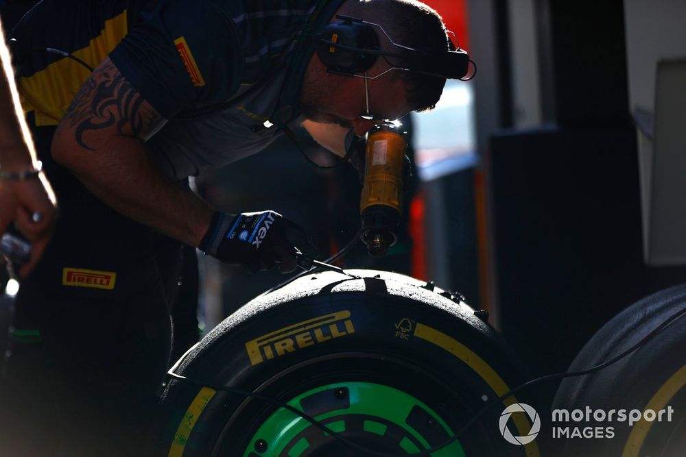 Een Pirelli-ingenieur schraapt een set banden die worden gebruikt door Sauber 