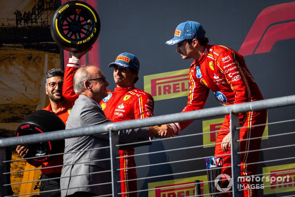 Carlos Sainz, Scuderia Ferrari, 2nd position, lifts his trophy and George Silbermann, President, ACCUS FIA, congratulates Charles Leclerc, Scuderia Ferrari, 1st position, on the podium