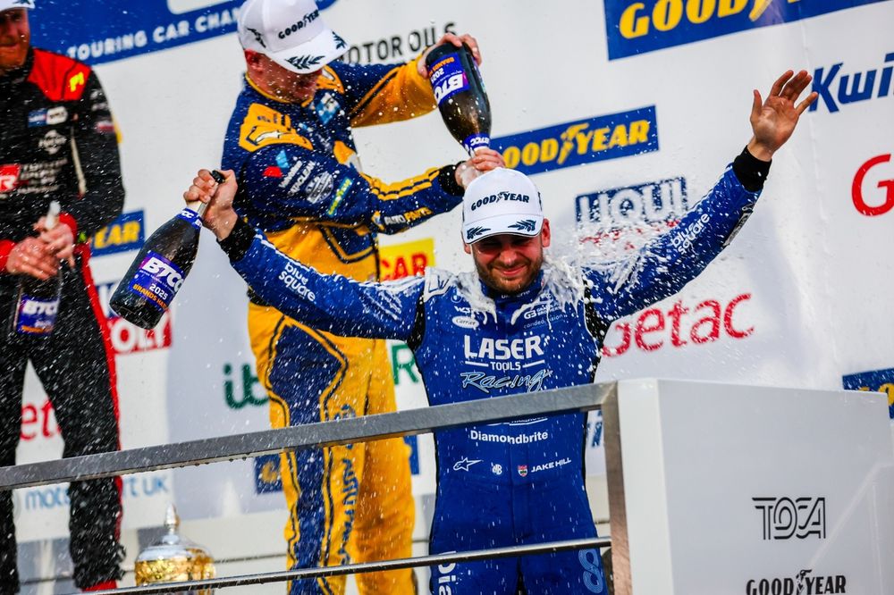 Outgoing champion Hill enjoys a soaking on the podium after his last BTCC race