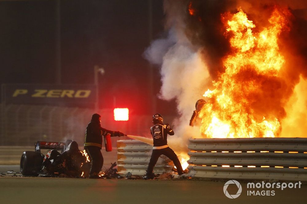 Romain Grosjean, Haas F1, emerges from flames after a horrific crash on the opening lap of the Bahrain Grand Prix, Marshals attend the accident